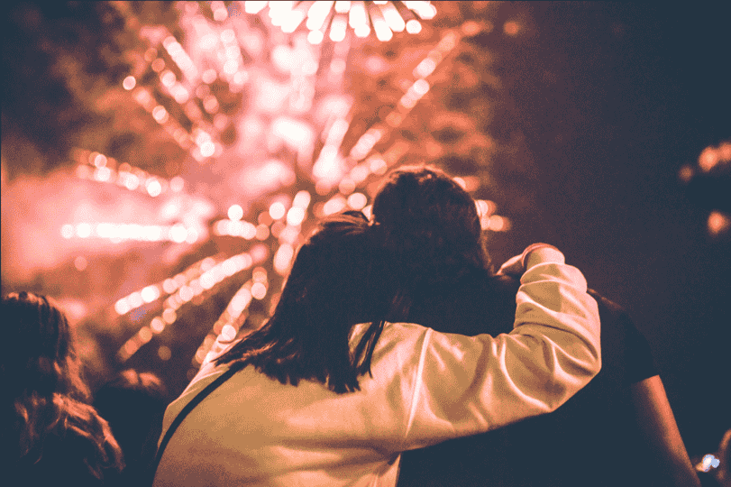 man and woman looking at fireworks