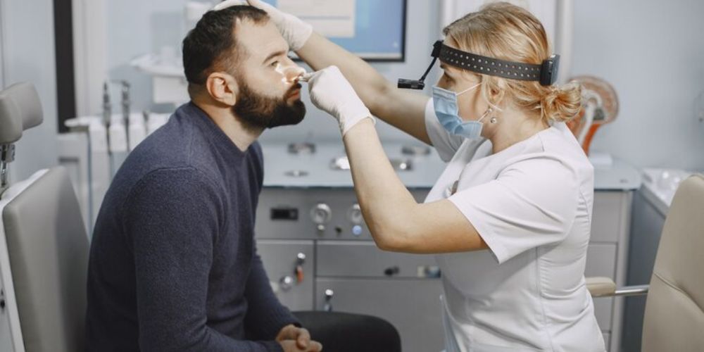 ENT doctor examining patient's nose