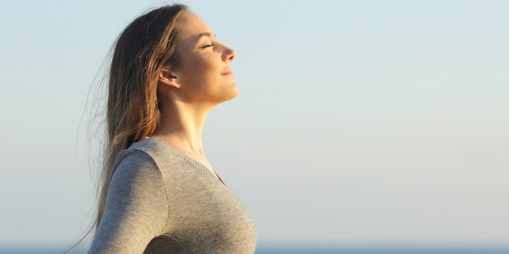 Photo of woman inhaling outdoors after allergy relief and better sleep quality