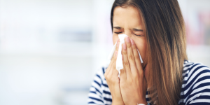 Photo of woman blowing into tissue