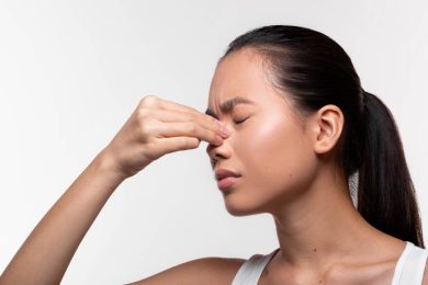 woman holding nose