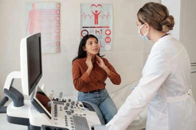 female patient touching her thyroid